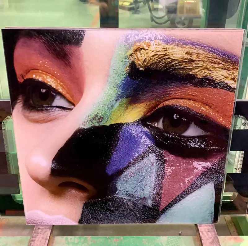 A sheet of glass with a colorful print of a painted face