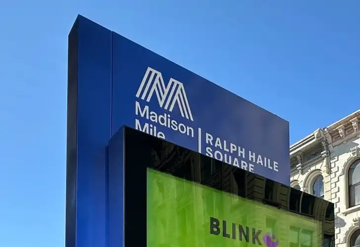 A white vinyl label of a logo and text reads 'madison mile ralph haile square'