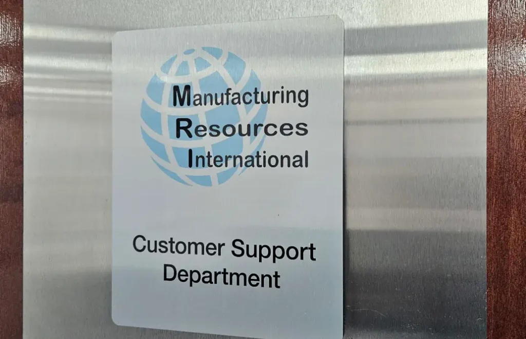 A metallic sign with MRI logo and globe and 'customer support department'