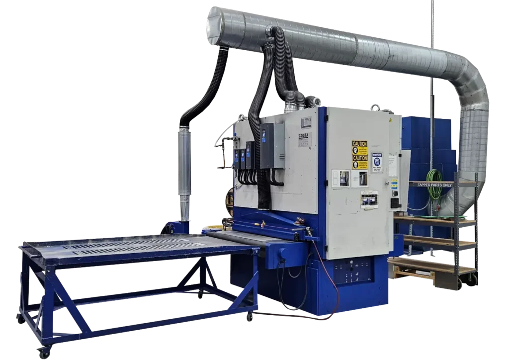 A large blue and grey machine with a table attachment and large ventilation tube hanging from the top