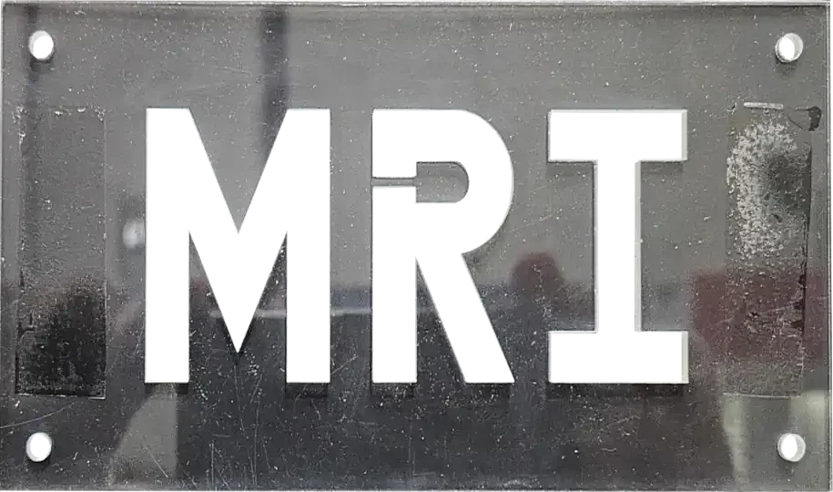 A think dark grey plastic plate with the letters 'MRI' and four small holes cut out
