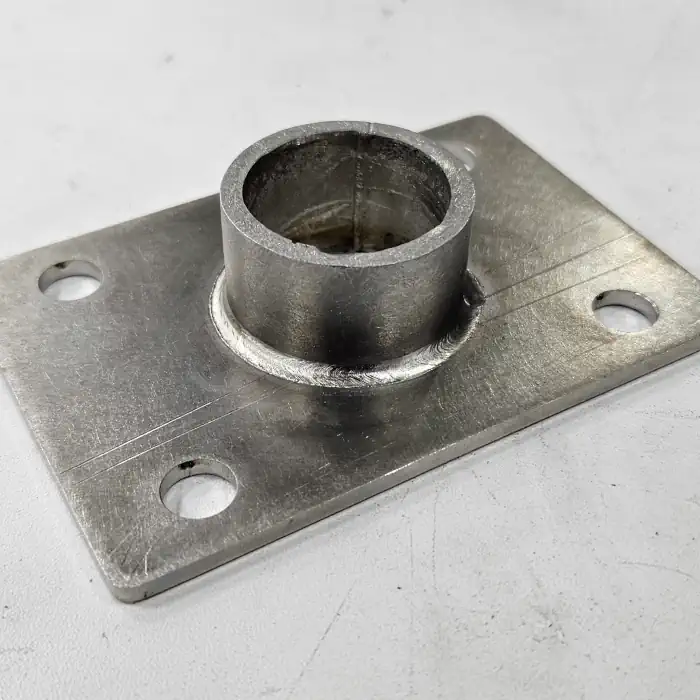 A metallic plate with a cylinder welded to one side